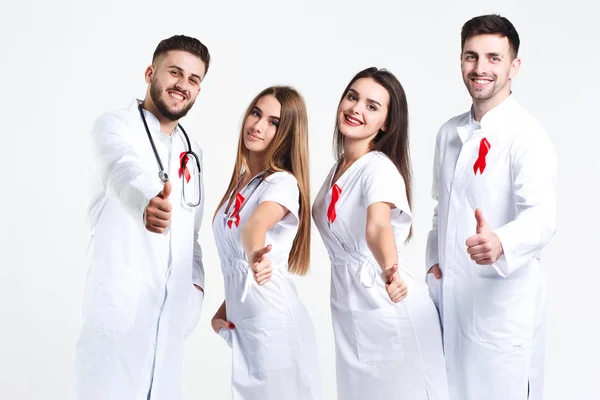 Group of doctors with red ribbons isolated on white background