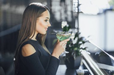 Yaz terasında ferahlatıcı kokteyl içme genç çekici kadın 