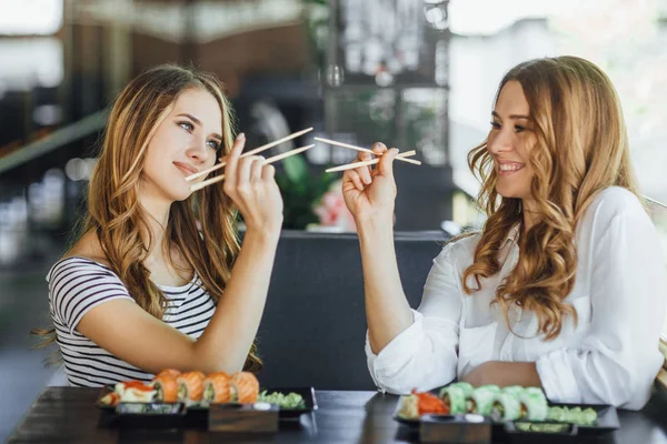 Anne ve kızı suşi restoranında, seçici odak yemek