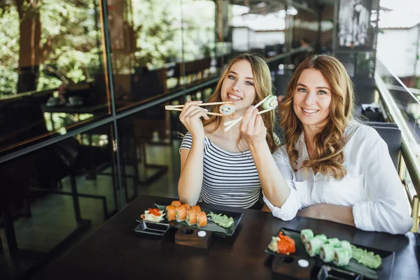Anne ve kızı suşi restoranında, seçici odak yemek