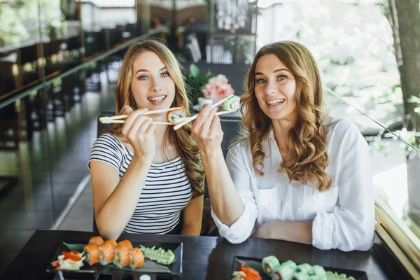 Anne ve kızı suşi restoranında, seçici odak yemek
