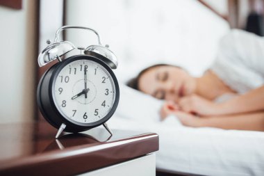 sabah, genç esmer kadın arka planda siyah çalar saat 