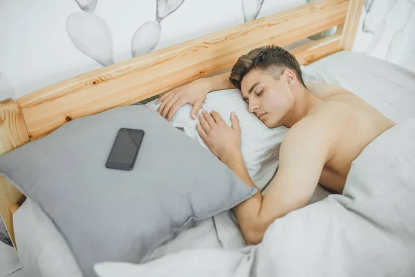 Mladý Pohledný Muž Spí Posteli Ráno — Stock fotografie