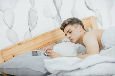 yatakta uyanma ve sabah bakarak yakışıklı delikanlı