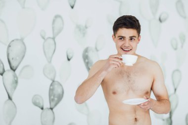 Genç yakışıklı adamla çıplak gövde odasında sabah kahve içme