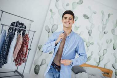 Evde giyiniyor ise beyaz gömlek kadar düğmelerini yakışıklı genç adam