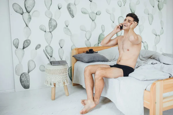 Jovem Homem Bonito Sentado Cama Quarto Falando Telefone — Fotografia de Stock