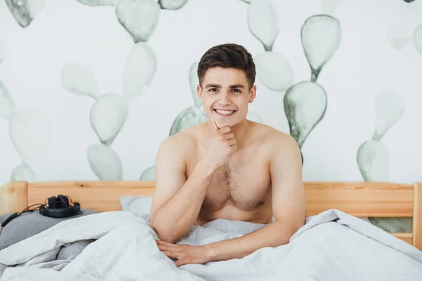 目を覚ますの部屋でベッドの上の若いハンサムな男 — ストック写真