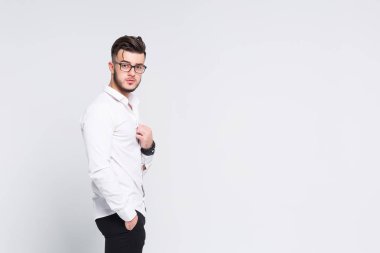 Beyaz gömlek ayakta beyaz arka plan üzerinde izole çapraz kollu yakışıklı işadamı