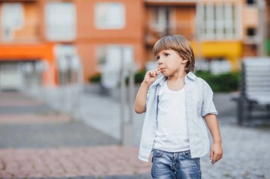 şık oğlan mavi tişört ve kot lolipop açık havada yaz yalama