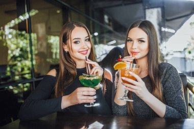 Modern Cafe yaz terasında oturup ve kokteyl içme genç güzel kadın