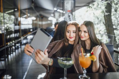 İki güzel kadın selfie yaz terasında modern Cafe nargile ile yapma
