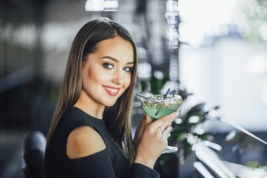 Yaz terasında ferahlatıcı kokteyl içme genç çekici kadın 