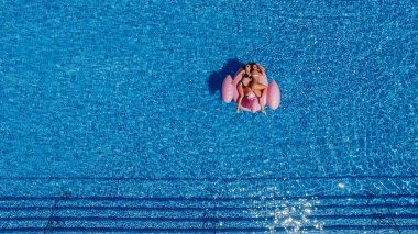 Havuzda rahatlatıcı güzel figürler ile iki mutlu genç kadının üst görünümü 
