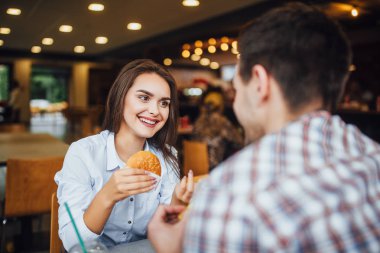 Fast food restoranında yemek ve eğlence, seçici odak sahip genç güzel Çift