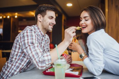 Genç çift fast food Restoran, adam kadını patates besleme eğleniyor