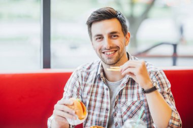yakışıklı delikanlı fast food Restoran, ön plan odaklanmak, lezzetli hamburger yemek