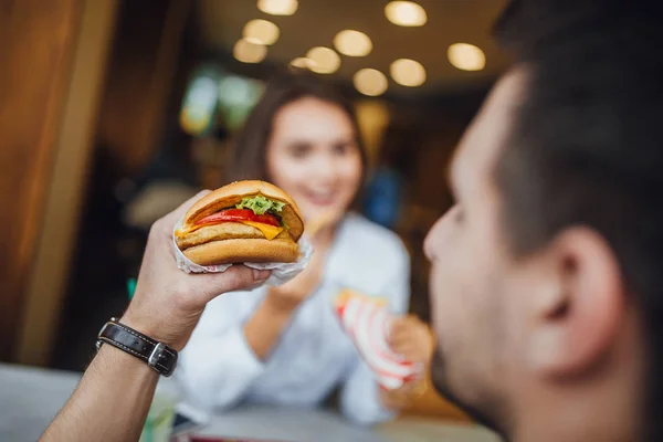 Young Caucasian Man Tasty Eating Hamburger Cheese Background Woman Selective — Stock Photo, Image