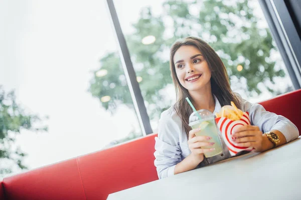 Ung Vacker Kvinna Äter Potatis Läckra Burger Mojito Och Tittar — Stockfoto