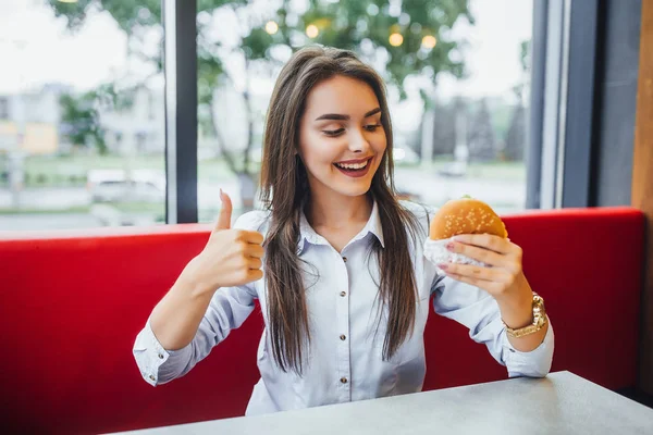 Jovem Bela Morena Mulher Comer Hambúrguer Mostrando Dedo Que Gosta — Fotografia de Stock