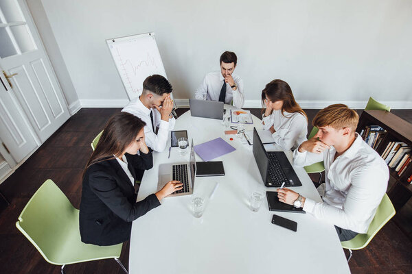 Group of young modern people brainstorming, sitting at modern office 