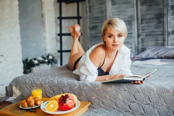 Blond Žena Čtení Knihy Při Pohledu Fotoaparát — Stock fotografie