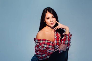 Ciddi kadın, mavi arka plan kameraya poz