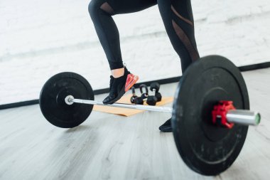 barbell ile sportif kadın görünümü gri katta kırpılmış