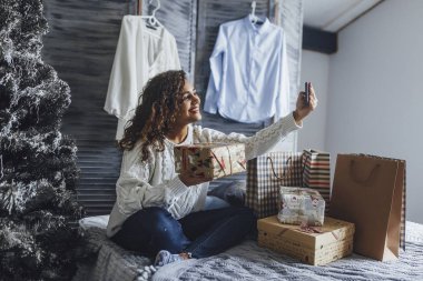 Video blog cep telefonu alarak ve yeni yıl hediye loft tarzı oda içinde gösterilen genç güzel blogger