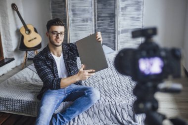 video blog için kayıt ve yeni laptop inceleme elinde gösterilen yakışıklı blogger