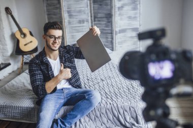 video blog için kayıt ve yeni laptop inceleme elinde gösterilen yakışıklı blogger