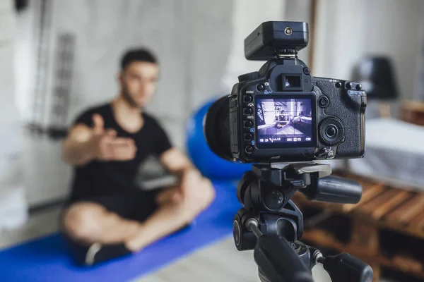 young fitness blogger writing video for blog and telling basic rules during workout