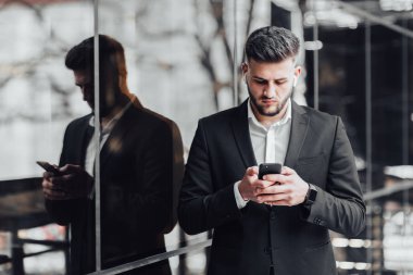 modern ofiste akıllı telefon kullanan işadamı, seçici odak