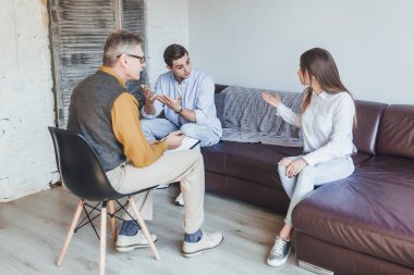 Genç çift psikolog resepsiyonunda tartışıyor.