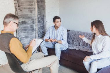 Genç çift psikolog resepsiyonunda tartışıyor.