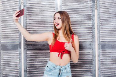 Kırmızı mayo güzel kadın gri arka plan üzerinde selfie yapma