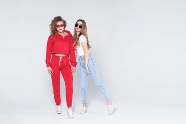 İki genç çekici kadın beyaz arka planda izole eğlenceli