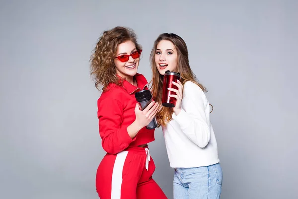 Dos Mujeres Jóvenes Chándal Rojo Jeans Con Copas Termo Las — Foto de Stock