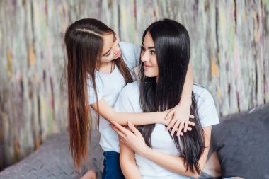 iki kız kardeş yatağa sarılmak, ön planda odaklanmak