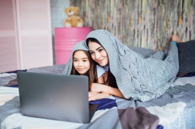 evde yatakta Laptop kullanan kardeşler, ön planda odaklanmak