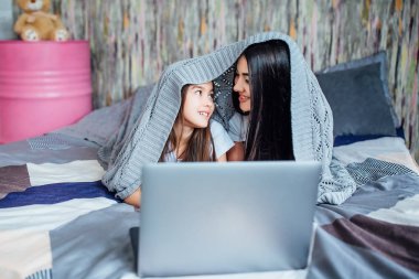 evde yatakta Laptop kullanan kardeşler, ön planda odaklanmak