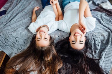 yatakta yatan mutlu kız kardeşi yükseltilmiş görünümü, seçici odak