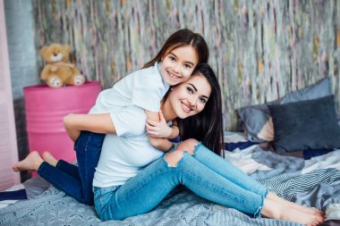 Evde yatakta oynayan iki mutlu kız, seçici odak