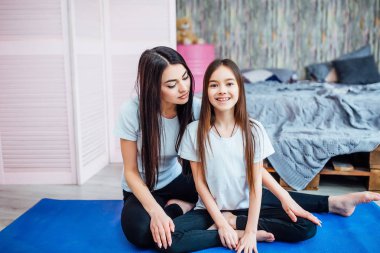 Güzel kardeşler mavi mat egzersizleri yapıyor, ön planda odaklanmak