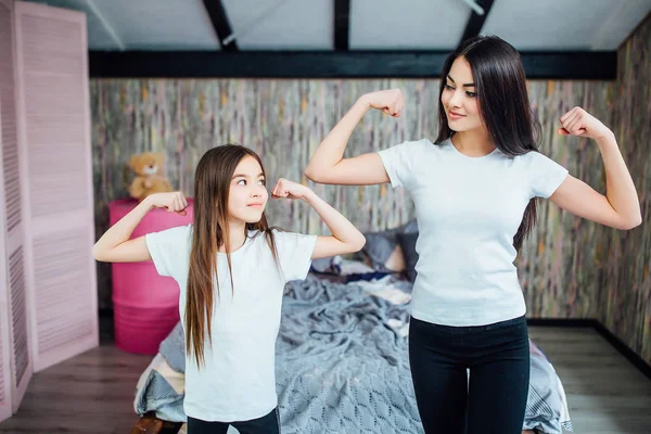 Two sisters doing exercises at morning, focus on foreground