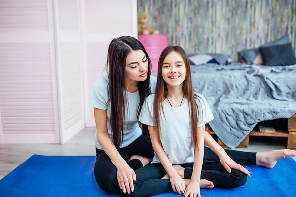 Güzel kardeşler mavi mat egzersizleri yapıyor, ön planda odaklanmak