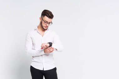 Genç esmer adam izle beyaz arka plan üzerinde izole bakarak