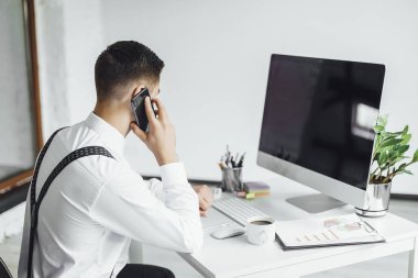 Ofiste çalışma masasında bilgisayar ile genç şık işadamı