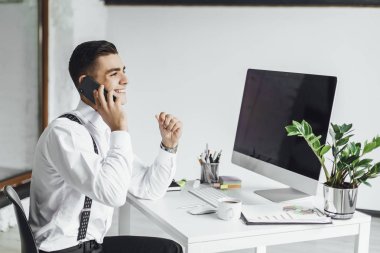 Ofiste çalışma masasında bilgisayar ile genç şık işadamı