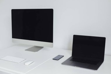 Beyaz masada masaüstü ve dizüstü bilgisayar ile çalışma alanı